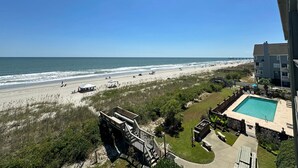 A beach view from a balcony with a swimming pool and outdoor seating. - Sea Shadow 306 - Oceanfront in Surfside Beach (Surfside Beach)
