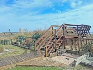 A wooden boardwalk leading to a wooden structure with a staircase.
