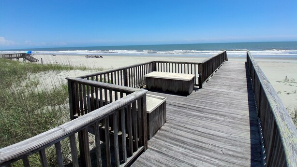 A wooden boardwalk leading to a beach with a clear view of the ocean. - Second Creek - Oceanfront in Garden City Beach (Garden City)