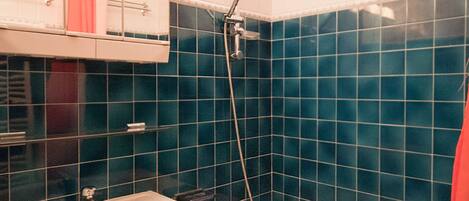 Een badkamer met twee wasbakken, een douche en een spiegel boven de wasbak.