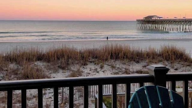 A beach view with a pier extending into the water. - Sand Dollar 101 - Oceanfront in Garden City Beach (Garden City)
