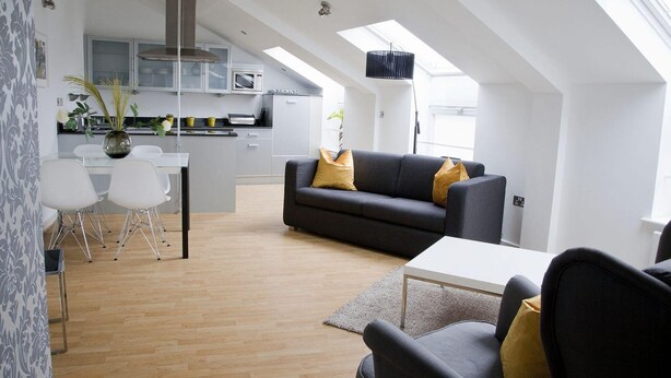A modern loft apartment with a kitchen, dining area, and living room.
