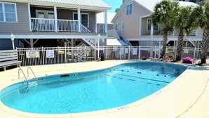A swimming pool with a white fence, a lifeguard stand, and a sign indicating shallow water. - Summer Winds 14 - Second Row Complex in Garden City Beach (Garden City)