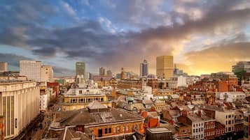 A cityscape with a mix of historic and modern buildings, including a prominent clock tower and a tall skyscraper.