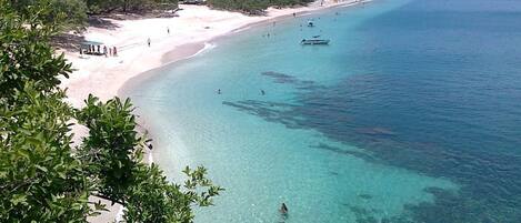 Una playa cerca, sillas reclinables de playa, toallas de playa