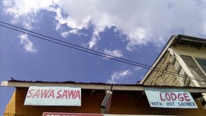 A building with signs for 'SAWA SAWA' and 'LODGUE WITH HOT SHOWER'. - Sawa Sawa Lodge - Adults Only (Nairobi)