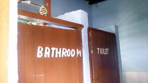 A bathroom with a wooden door labeled "BATHROOM" and another door labeled "TOILET". - Sawa Sawa Lodge - Adults Only (Nairobi)