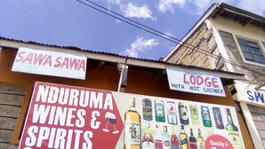 A building with signs for 'SAWA SAWA' and 'LODGUE WITH HOT SHOWER'. - Sawa Sawa Lodge - Adults Only (Nairobi)