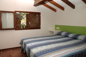 A bedroom with a bed, a window, and a green headboard.