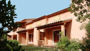 Un edificio de dos pisos con techo de tejas y pared de piedra frontal.