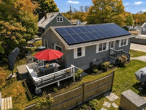 A residential house with a solar panel roof, a fenced backyard, and a patio with outdoor furniture. - Ryal Side Hideaway: Beverly Charm (Beverly)