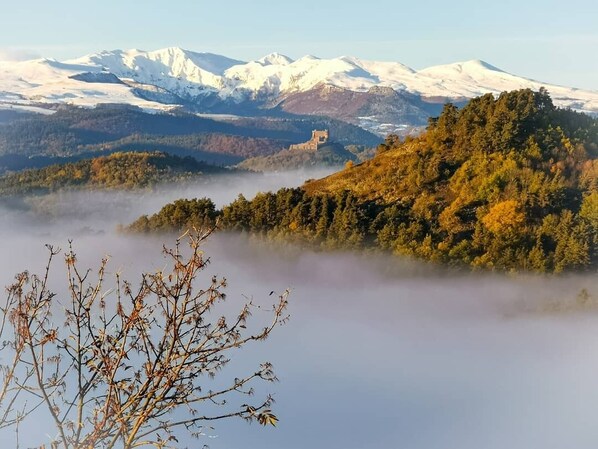 A mountainous landscape with a castle on a hill, surrounded by autumn foliage and snow-capped peaks. - La Rosière 2. A heavenly place in the midst of nature, peace and quiet. (Auzelles)