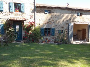 A stone building with a tiled roof, a blue door, and potted plants. - La Rosière 2. A heavenly place in the midst of nature, peace and quiet. (Auzelles)