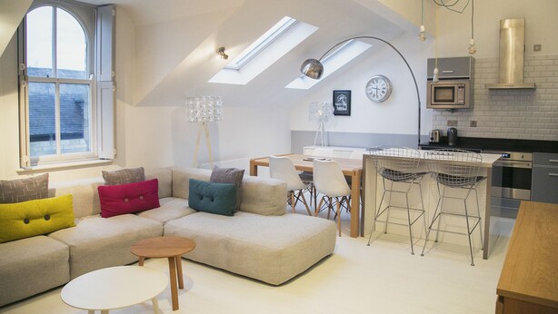 Un moderno loft con zona pranzo, cucina e un'ampia finestra con lucernari.