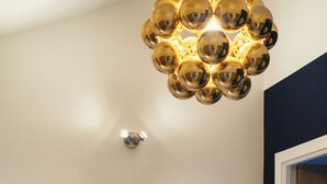 Un bagno con uno specchio rotondo, un armadietto in legno e una lampada a soffitto.