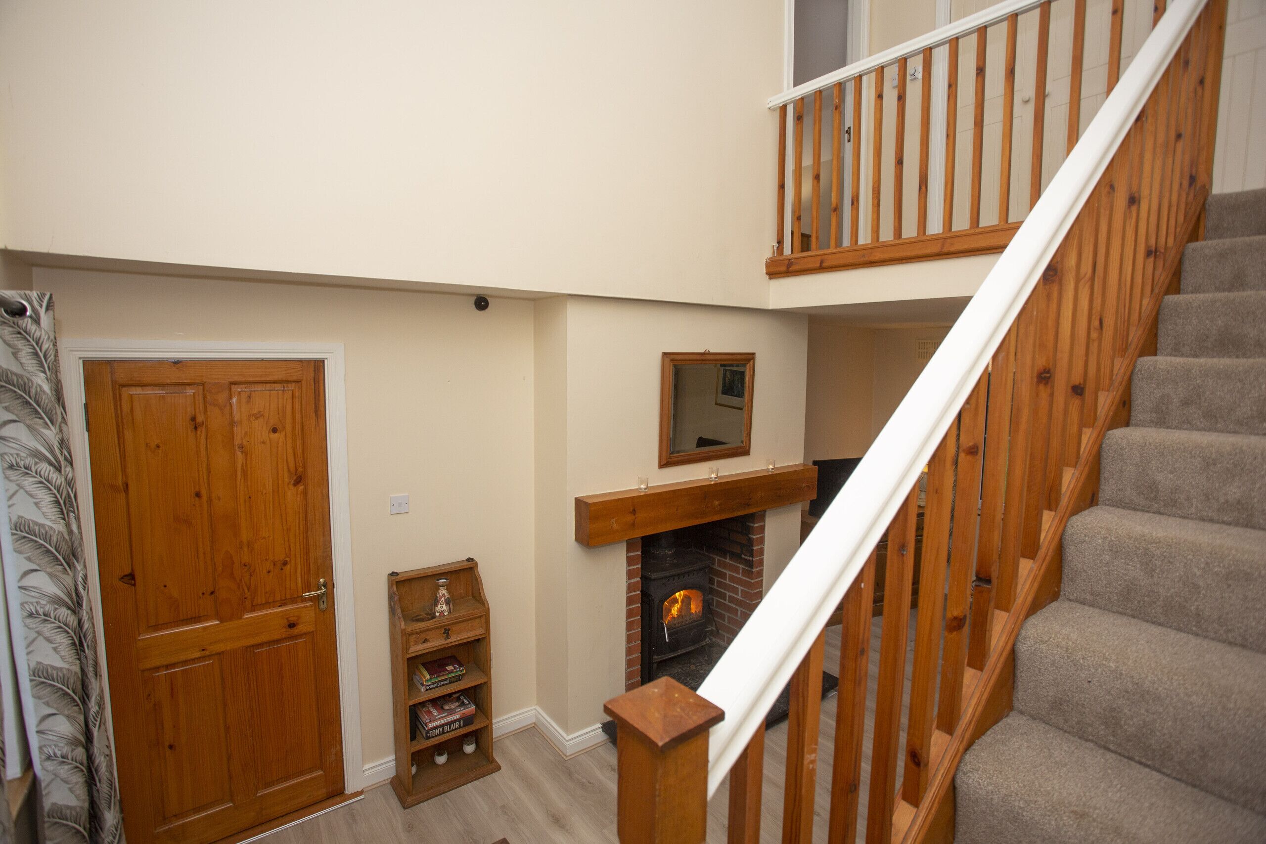 A staircase with wooden railings and carpeted steps leading to a second floor.