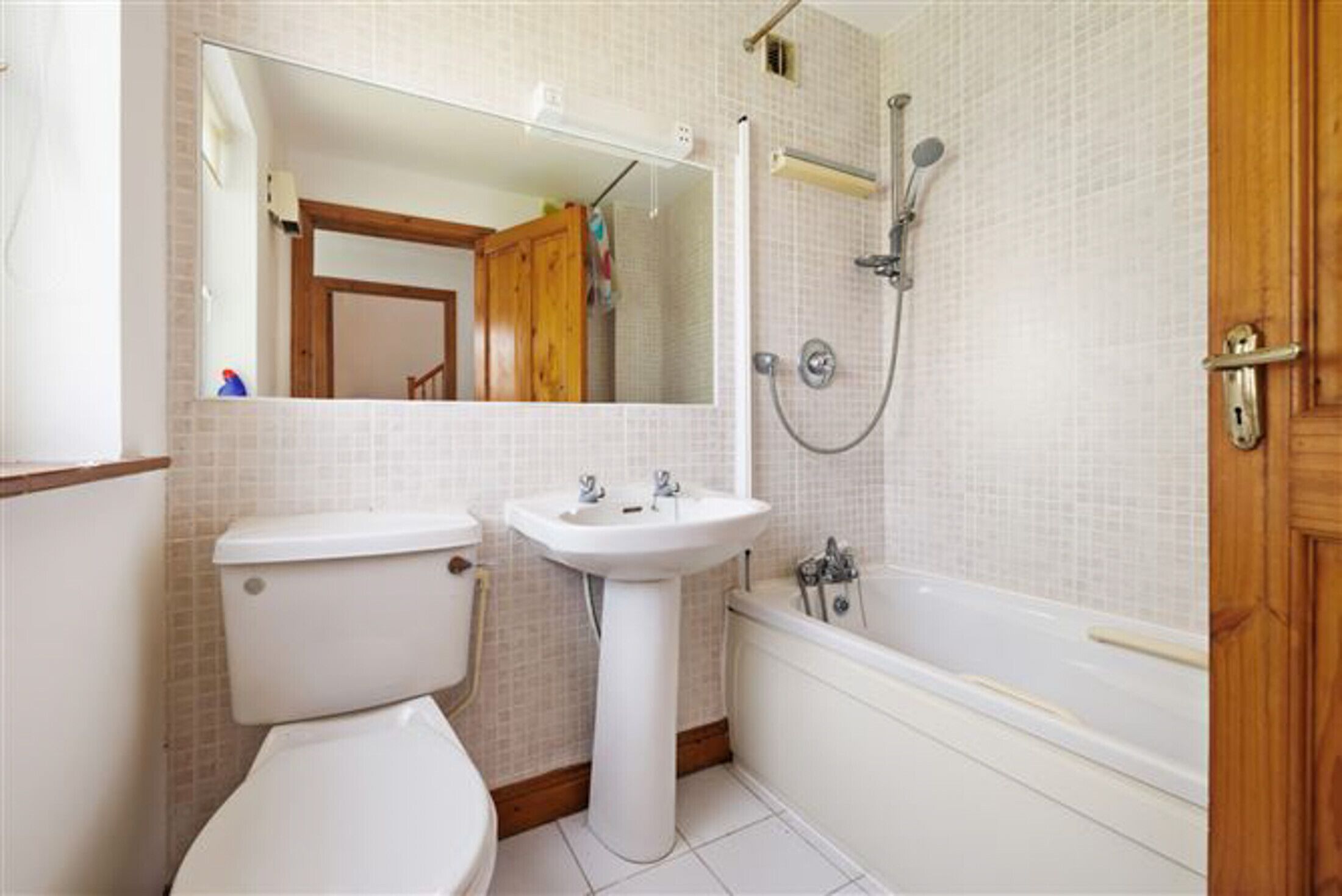 A bathroom with a toilet, sink, and bathtub.
