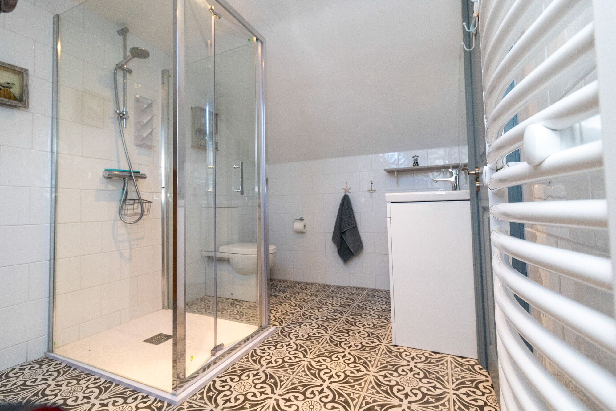 Un baño con cabina de ducha de vidrio, inodoro y lavabo.