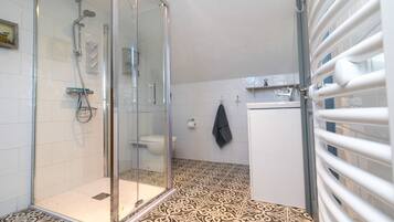 Ein Badezimmer mit Duschkabine, Toilette und Waschbecken.