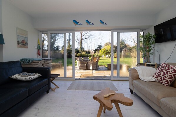 A living room with a sofa, a coffee table, and a dining area with chairs and a table.