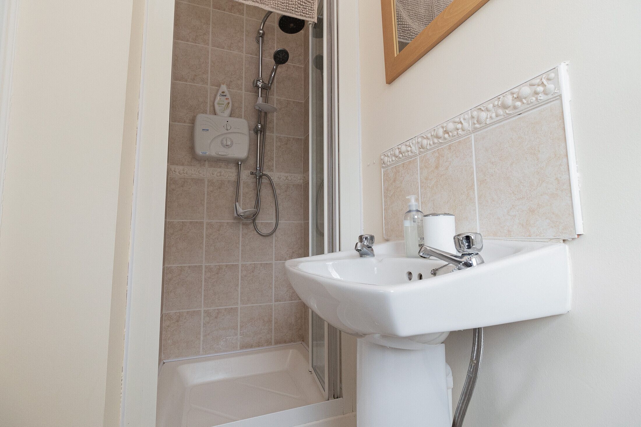 A bathroom with a shower, a sink, and a toilet.