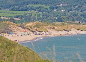 A beach with people, tents, and a lifeguard tower.