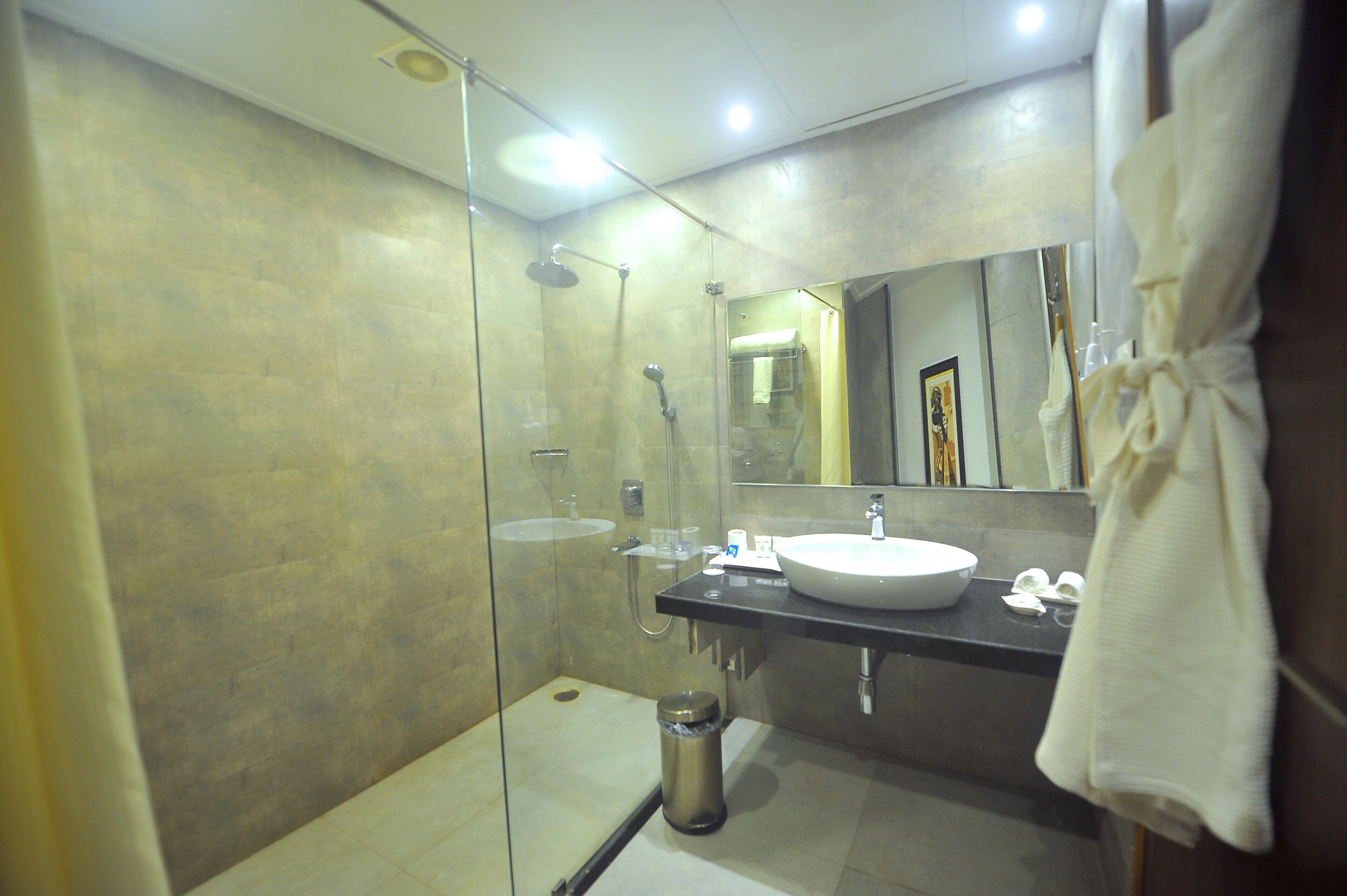 Une salle de bain moderne avec une douche à parois de verre, un lavabo et un miroir.