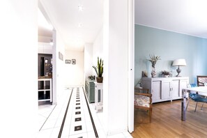 Uma cozinha moderna com armários brancos, uma geladeira e um espaço de refeições com mesa e cadeiras.
