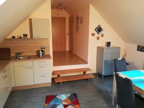 Kjøleskap, mikrobølgeovn, ovn og høy barnestol