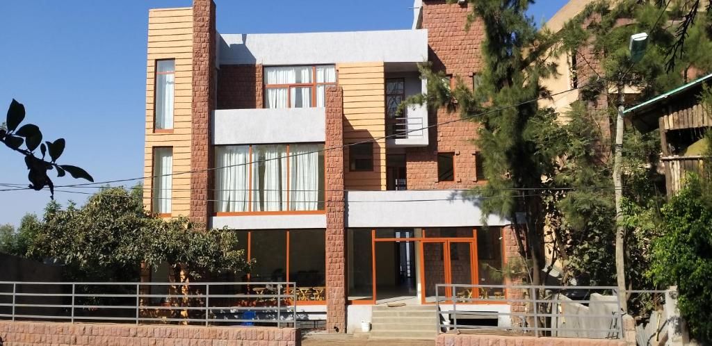 A modern two-story building with a brick facade, large windows, and a visible entrance with steps.