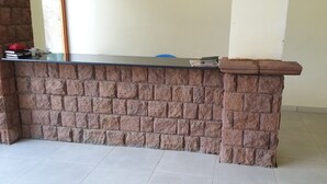 Una encimera de piedra con suelo de baldosas y una pared lisa al fondo.