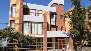 Un edificio moderno con una combinación de ladrillo y fachadas blancas, ventanas grandes y un balcón visible.