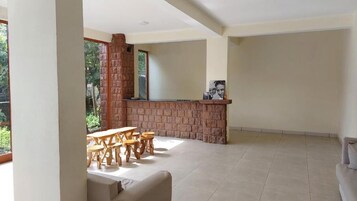 Un espacio habitable integrado con chimenea de ladrillo, una mesa de comedor con sillas y un sofá.