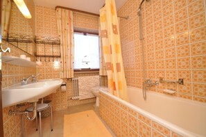 A bathroom with a sink, toilet, and bathtub. - Appartementhaus Alpenrose (Wallgau)