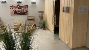 A room with a wooden sauna door, a chair, a plant, and a wall-mounted sauna control panel. - Baabe villas ensemble VE 19 sea view romanticism Ref. 215919 (Baabe)