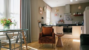 Une cuisine moderne avec un coin repas, un fauteuil confortable et une table basse.