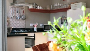 Une cuisine moderne équipée d’un four Bosch, d’un four à micro-ondes et d’un appareil à pain, le tout posé sur le plan de travail.
