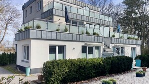 Un moderno edificio a più piani con balconi, una scala e un giardino curato.