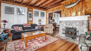 A cozy living room with a stone fireplace, wooden beams, and a large fish mounted on the wall. - WELCOME TO HARBOR HOUSE!  STEP BACK IN TIME AND RELAX AT THE BEACH... (Holland)