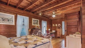 A wooden cabin bedroom with a large bed, a desk, and a chair. - WELCOME TO HARBOR HOUSE!  STEP BACK IN TIME AND RELAX AT THE BEACH... (Holland)