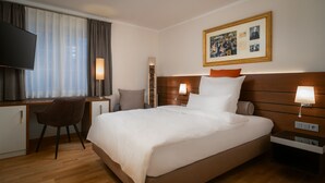 A hotel room with a large bed, a desk, a chair, and a TV. - Hotel zur Post Riesenbeck (Hoerstel)