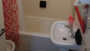 Un bagno con doccia, un water e un lavandino.