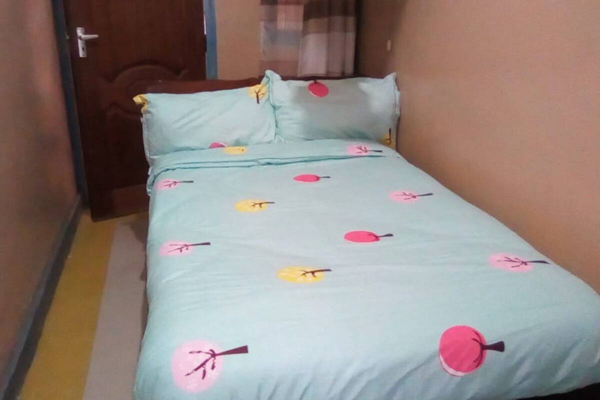 Una cama con una colcha azul claro con motivos florales en rosa y amarillo.