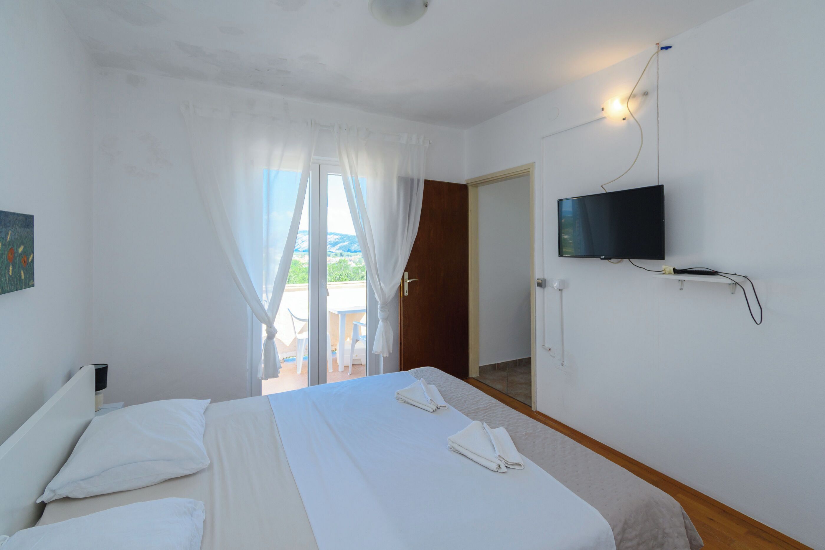 Una habitación de hotel con cama, televisión y vistas al exterior.