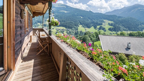 Une terrasse en bois offrant une vue sur un paysage montagneux.