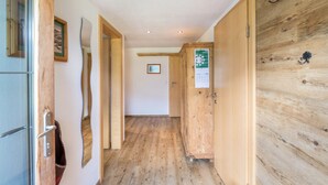 Un couloir avec un plancher en bois, un réfrigérateur et un meuble en bois.