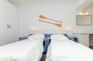 A hotel room with two beds, a wardrobe, a desk, and a mirror. - Apartments Beach House Paradiso (Podgora)