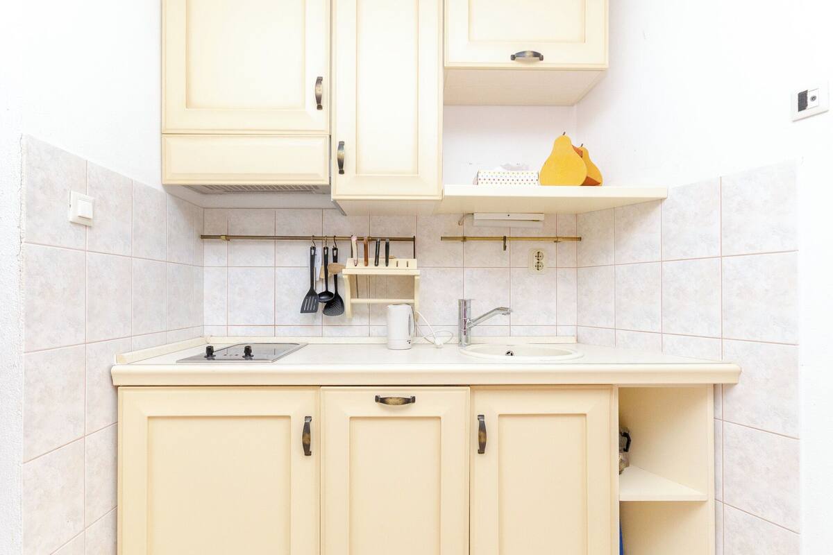 A kitchen with white cabinets, a sink, and a countertop.