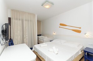 A hotel room with two beds, a desk, and a TV. - Apartments Beach House Paradiso (Podgora)