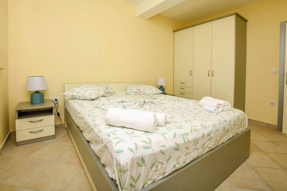 A bedroom with a bed, nightstands, a wardrobe, and a lamp.